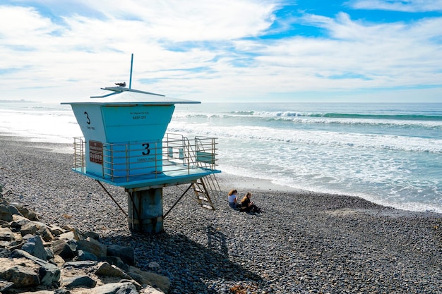 Foto una torre bagnino su una spiaggia con l'oceano sullo sfondo.