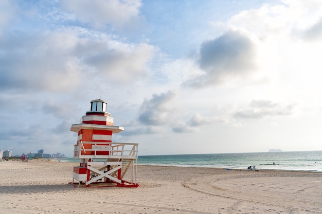 Lifeguard tower at Miami beach in Florida, USA. Red and white striped lighthouse design lifeguard tower. Seaside holidays. Summer vacation. Travel destination.