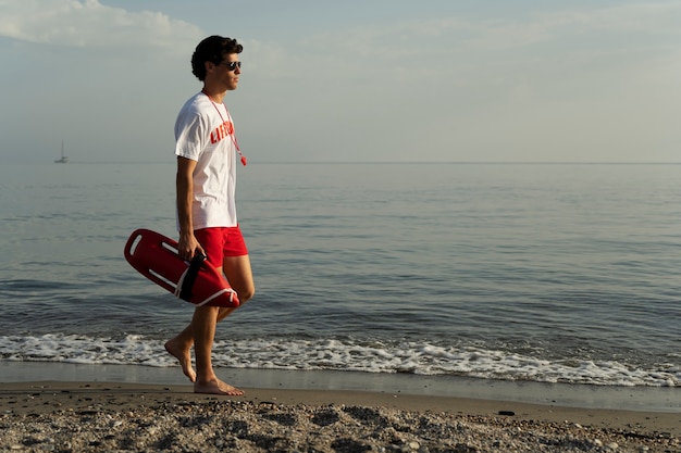 Lifeguard walking on beach side view