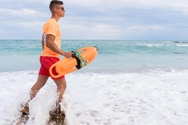 A lifeguard with a float on duty on the beach