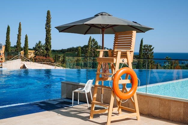 The lifeguard39s post is under a sun umbrella A life preserver hangs nearby Water safety concept