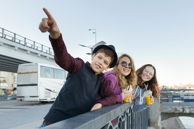 Lifestyle of adolescents, boy and two teen girls are walking in the city