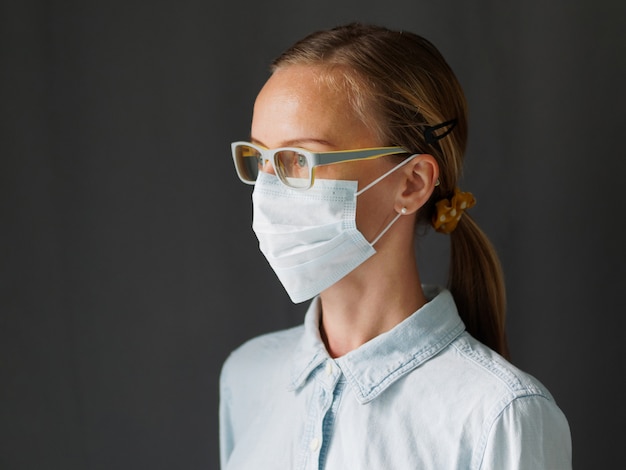 Lifestyle afbeelding. Portretvrouw die chirurgisch medisch masker voor coronavirus dragen. Covid-19 concept