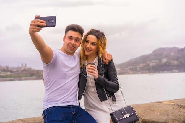 Lifestyle of a Caucasian couple sightseeing and enjoying the vacations. Taking a picture with the mobile phone