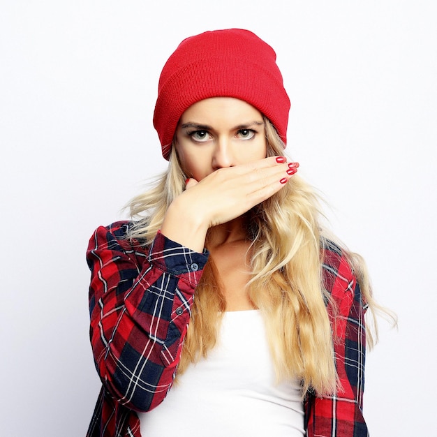 Lifestyle concept jonge hipster blonde vrouw met lichte sexy make-up dragen van stijlvolle stedelijke plaid shirt en rode hoed