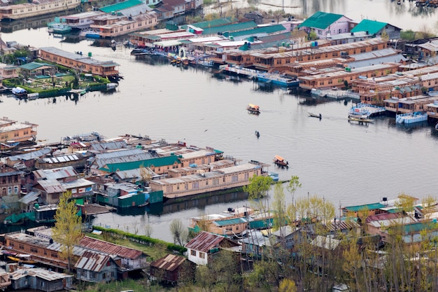  Lifestyle in Dal lake, man drive the boat in middle of the Dal lake and mountain backgrou