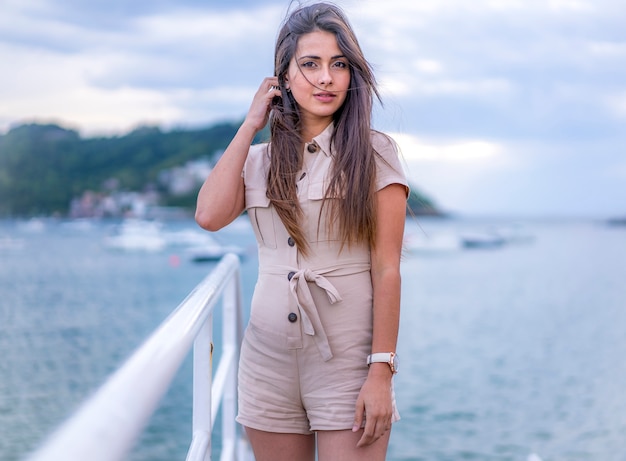 Lifestyle, een mooie brunette op de promenade naast een strand