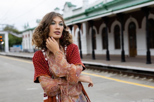 Lifestyle elegant young woman standing down the street in a trendy outfit