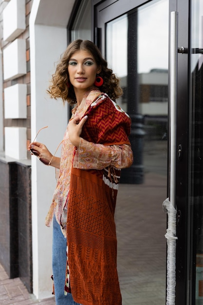 Lifestyle elegante jonge vrouw die op straat staat in een trendy outfit