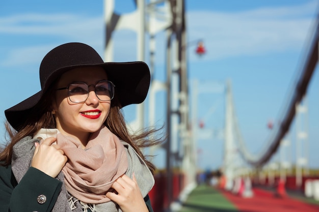 Lifestyle fashion portrait of beautiful brunette model walking at the city, wearing trendy outfit