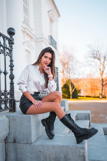 Lifestyle fashionable pose of a young brunette in a black leather