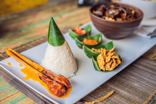 ライフスタイルフード。ご飯、魚のフライ、きのこ、各種タレが入った一品。