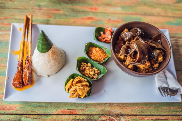 Foto cibo stile di vita. un piatto composto da riso, pesce fritto con funghi di bosco e diversi tipi di salse.