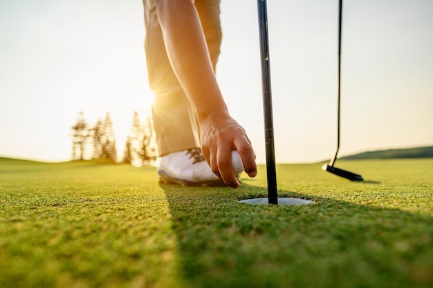 Lifestyle, golf, activity, outdoor, sport, golfer concept. Golfers collect golf balls that hole in the green grass on the golf course in the morning.