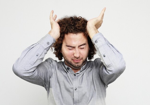 Photo lifestyle health and people concept close up of frustrated young man with head in hand