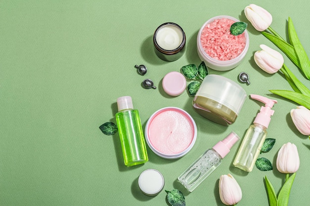 lifestyle and healthy concept spa setting for massage treatment body care and face beauty green and pink tones hard light dark shadow top view