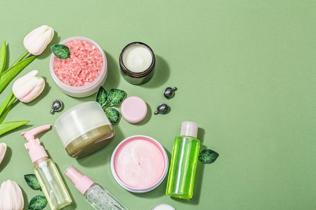 lifestyle and healthy concept spa setting for massage treatment body care and face beauty green and pink tones hard light dark shadow top view