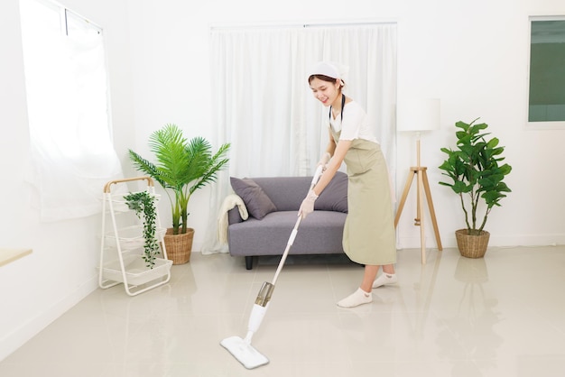 Lifestyle in living room concept Young Asian woman cleaning the floor with vacuum cleaner