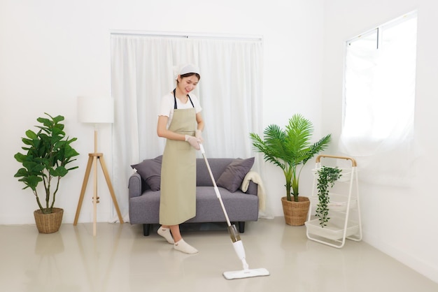 Lifestyle in living room concept Young Asian woman cleaning the floor with vacuum cleaner