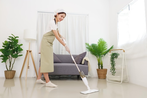 Lifestyle in living room concept Young Asian woman cleaning the floor with vacuum cleaner