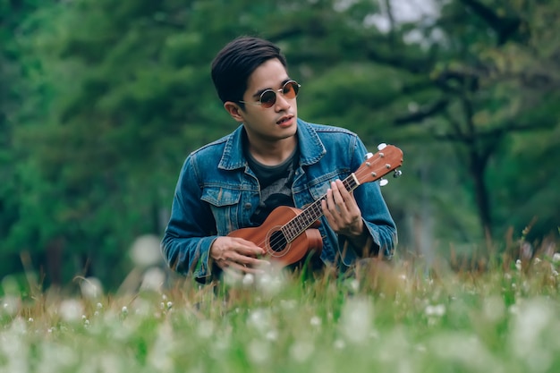 Uomo di stile di vita rilassante nel parco con il suo tono vintage ukulele