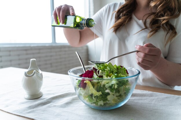 Lifestyle-momenten van een jonge vrouw thuis. Vrouw bereidt een salade in de keuken