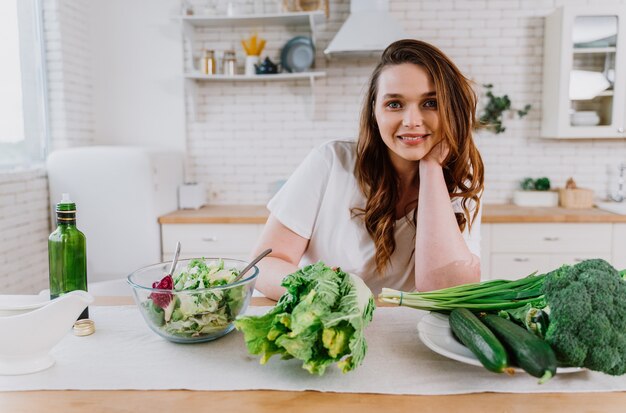 Lifestyle-momenten van een jonge vrouw thuis. Vrouw bereidt een salade in de keuken