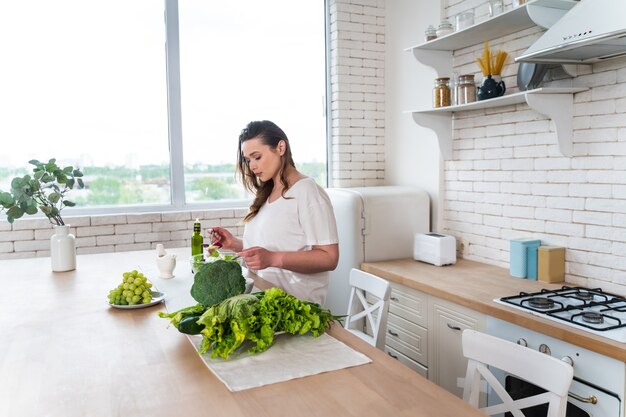 Lifestyle-momenten van een jonge vrouw thuis. Vrouw bereidt een salade in de keuken