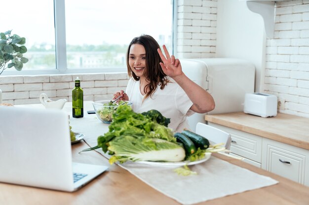 Lifestyle-momenten van een jonge vrouw thuis. Vrouw bereidt een salade in de keuken