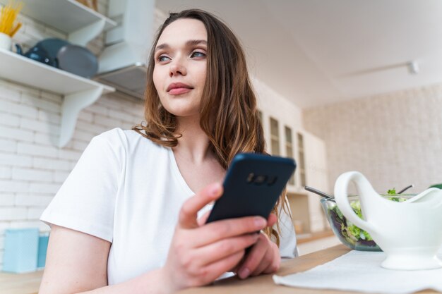 Lifestyle-momenten van een jonge vrouw thuis. Vrouw bereidt een salade in de keuken