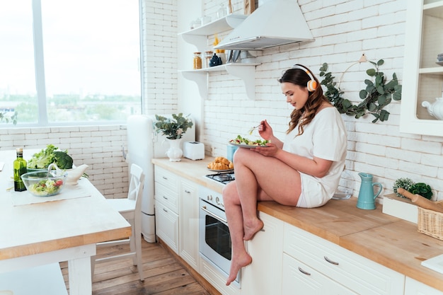 Lifestyle-momenten van een jonge vrouw thuis. Vrouw bereidt een salade in de keuken