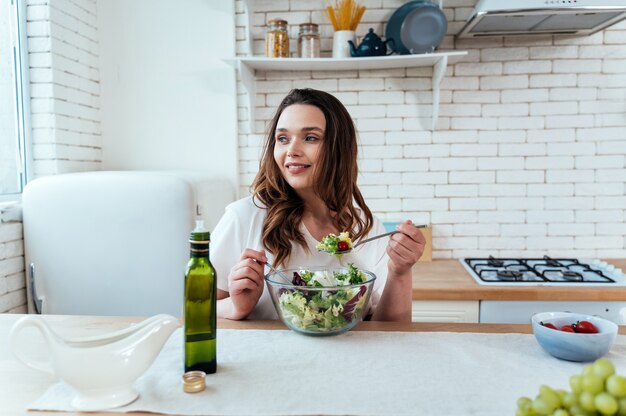 Lifestyle moments of a young woman at home. Woman preparing a salad in the kitchen