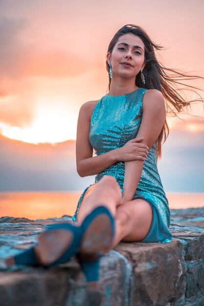 Lifestyle, pensive caucasian brunette in an orange sunset sitting, looking straight ahead