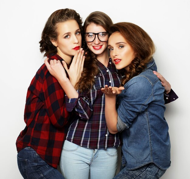 Lifestyle and people concept: Fashion portrait of three stylish sexy girls best friends, over white background. Happy time for fun.