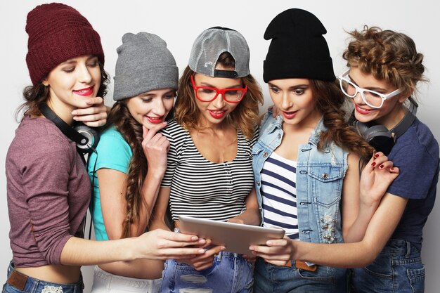 Photo lifestyle and people concept: five hipster girls friends taking selfie with digital tablet, studio shot over gray background