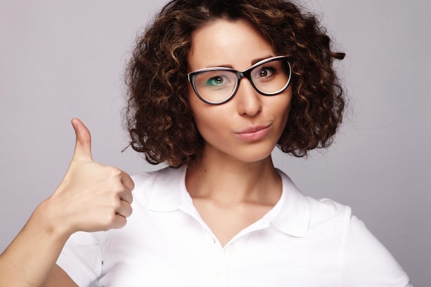 ライフスタイルと人々の概念親指をあきらめる幸せな女性