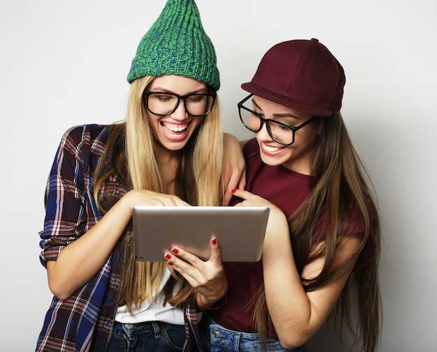 Lifestyle and people concept:  two hipster girls friends use digital tablet