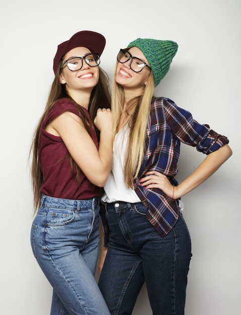 Концепция образа жизни и людей: две молодые девушки-подруги стоят вместе и веселятся