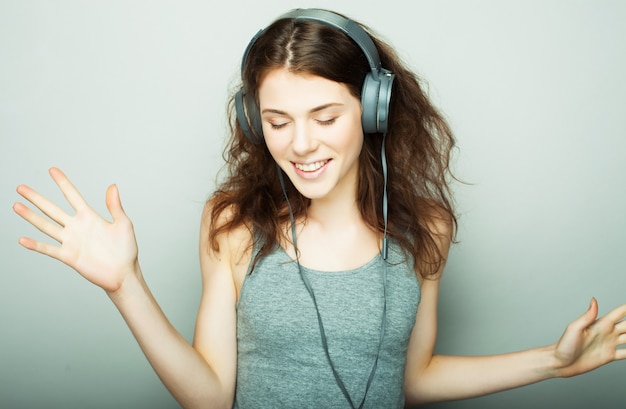 ライフ スタイルと人々 のコンセプト: 音楽を聴くヘッドフォンを持つ若い幸せな女性。