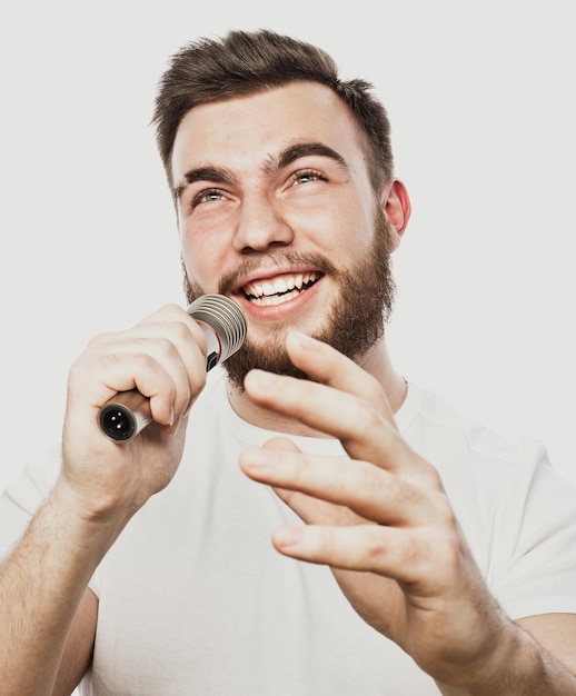 Lifestyle and people concept young man singing with microphone