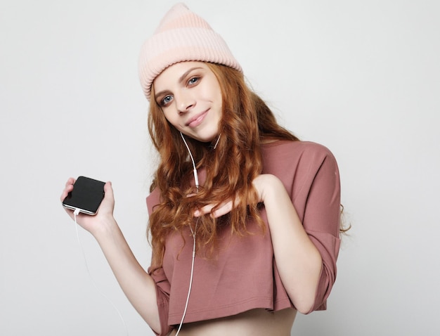 Photo lifestyle and people concept young woman in headphones with smartphone listening to the music