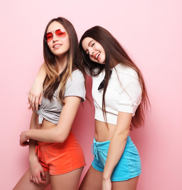 Lifestyle people teens and friendship concept happy smiling pretty teenage girls or friends hugging over pink background