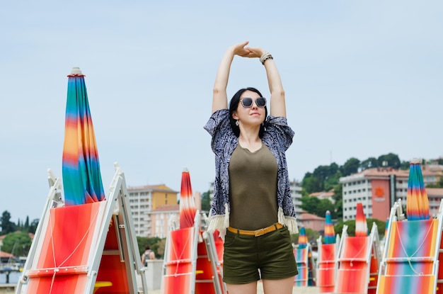 Photo lifestyle portrait beautiful asian woman walking relaxing in sunny day at beach summer dancing adriatic sea