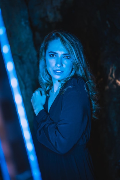 Lifestyle portrait of a caucasian girl in a cave with blue led light