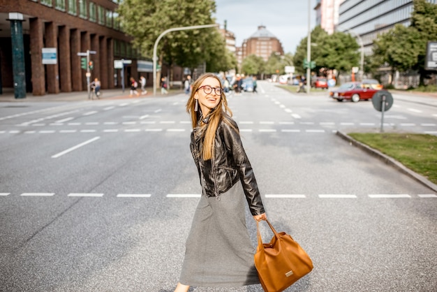 Фото Образ жизни портрет молодой стильной деловой женщины, идущей по улице в городе гамбург, германия