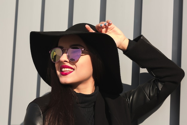 Lifestyle portrait of positive brunette woman with bright makeup and shiny hair posing in sun light