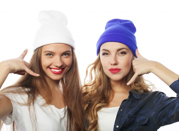 Lifestyle portrait of two pretty teen girlfriends smiling and ha