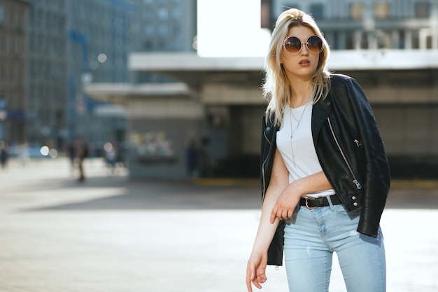 Lifestyle portrait of young luxury girl wearing vintage sunglasses and fashionable outfit. Space for text