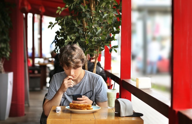 Lifestyle portrait of a young man using a smart phone outdoors