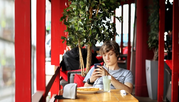 Lifestyle portrait of a young man using a smart phone outdoors